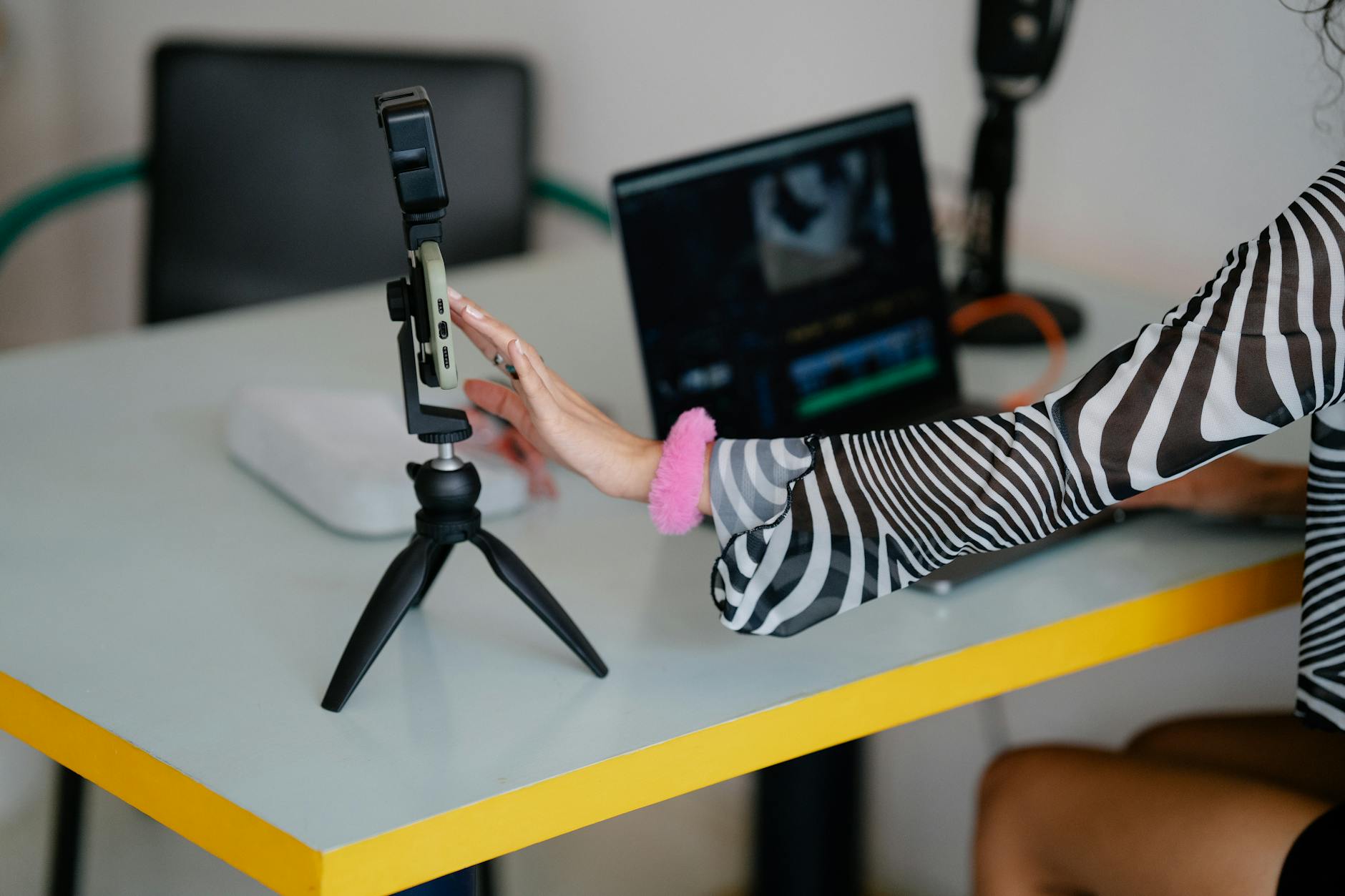 Content creator using an AI video editing tool with chat interface to create videos on a laptop